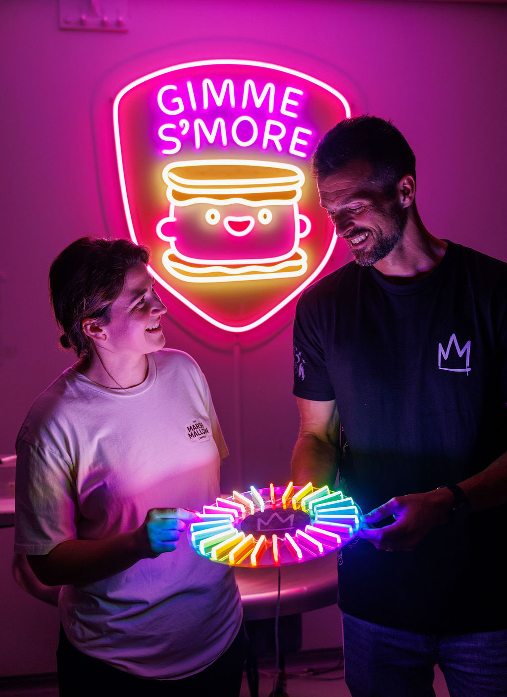 Stephen Pastor and a team member holding a colour-changing neon piece at Kings of Neon