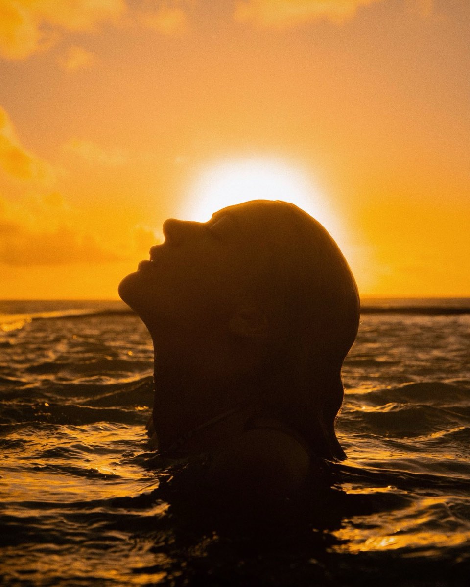 A swimmer surfacing into the sunrise